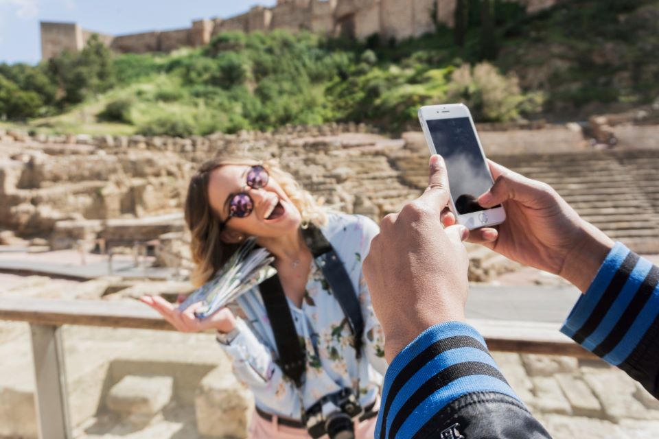 Taking a photo of laughing girlfriend in front of a monument.
